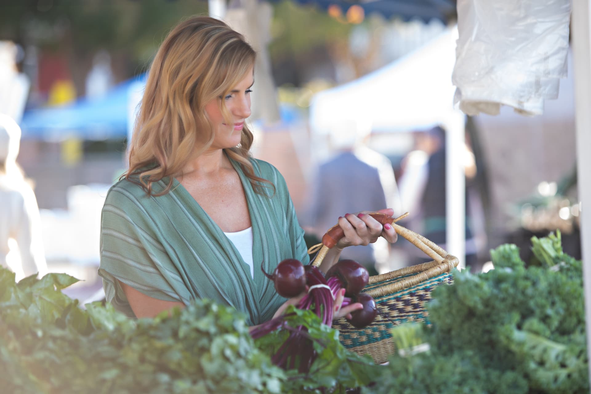 Kris Ellis selecting fresh produce at the farmers market