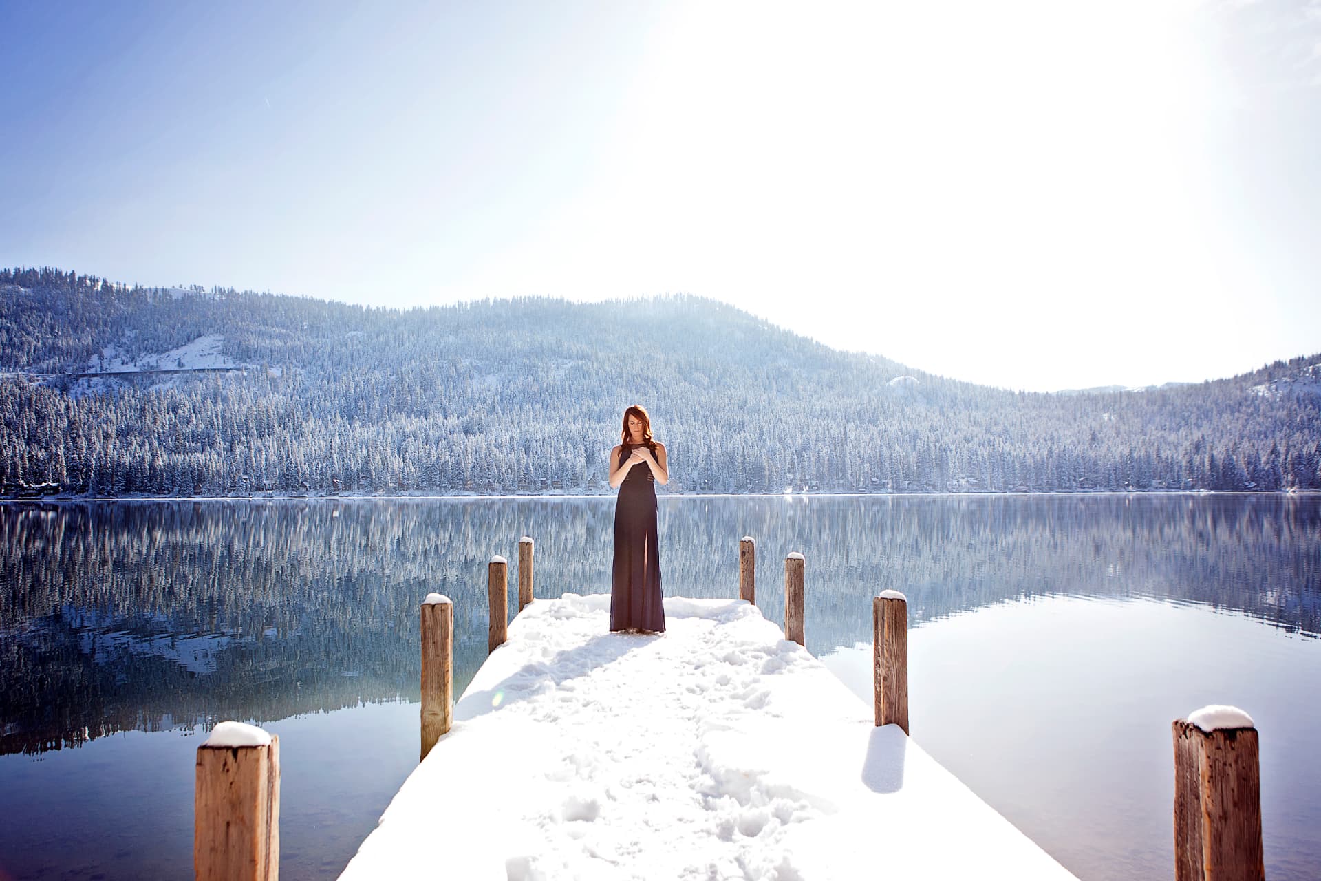 Kris Ellis pausing for meditation on a snowy lakeside dock